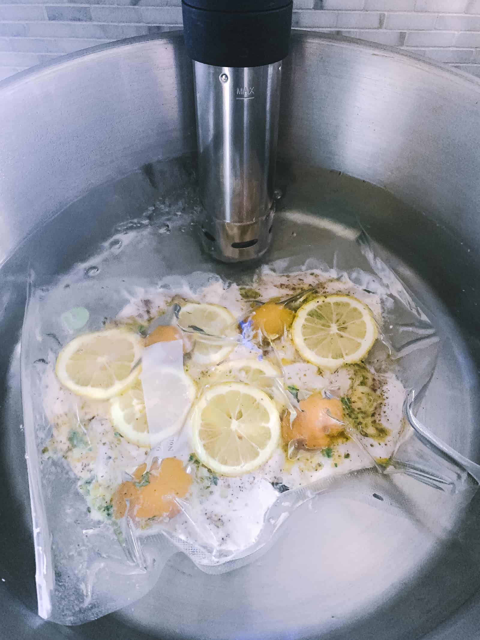 bag of chicken and lemons in a sous vide immersion circulator.