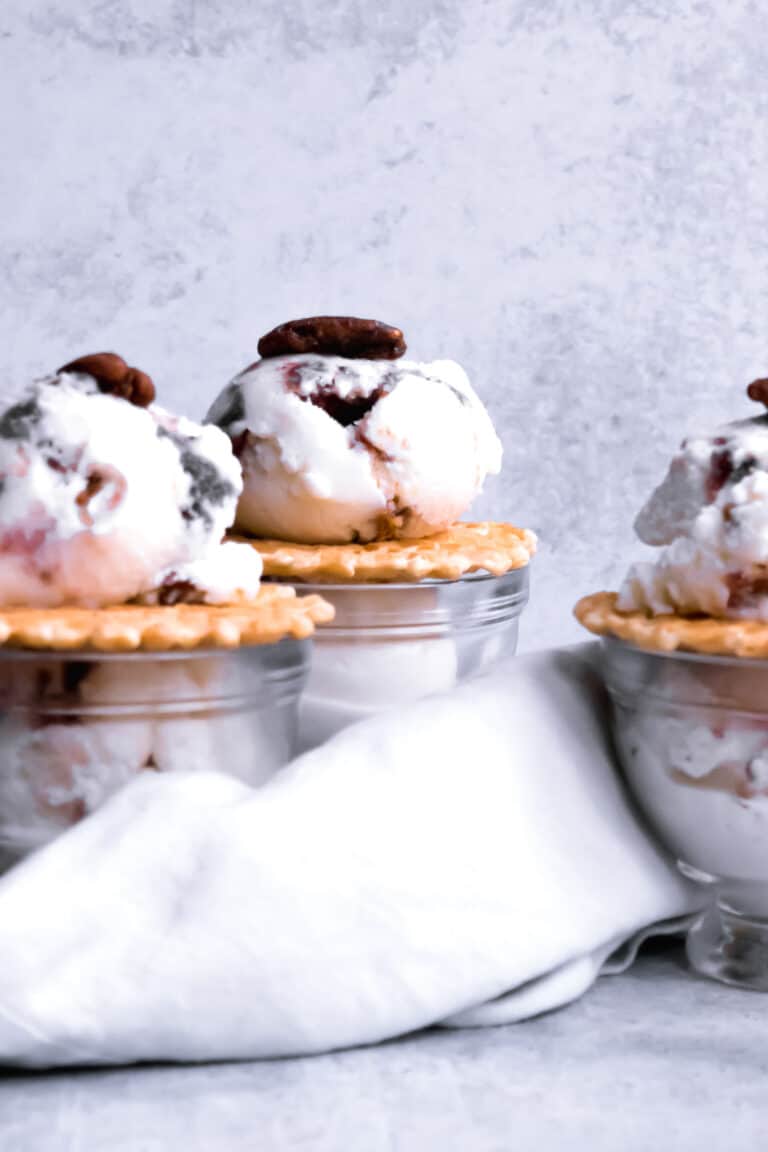 three bowls of blackberry and whiskey ice cream on pizzelle cookies.