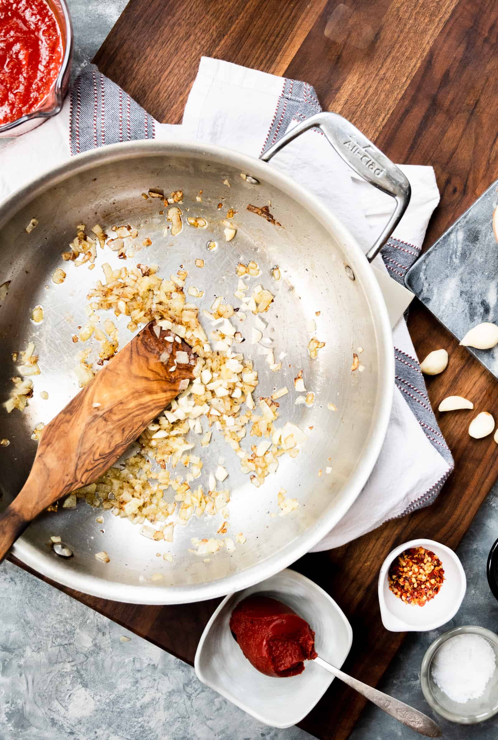 a pan of sauteed onions on a wooden board.