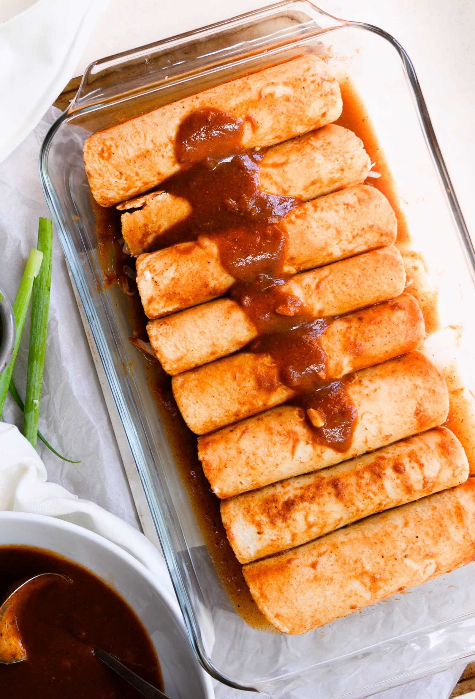 chicken enchiladas in a pan with sauce before baking