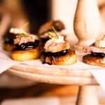 closeup of potato with cherry compote and beef on top and a little horseradish cream.