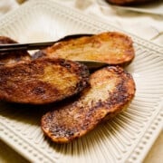 white ceramic platter of roasted potato halves.