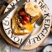 bread with eggs in the middle cut open and yolk spilling out.