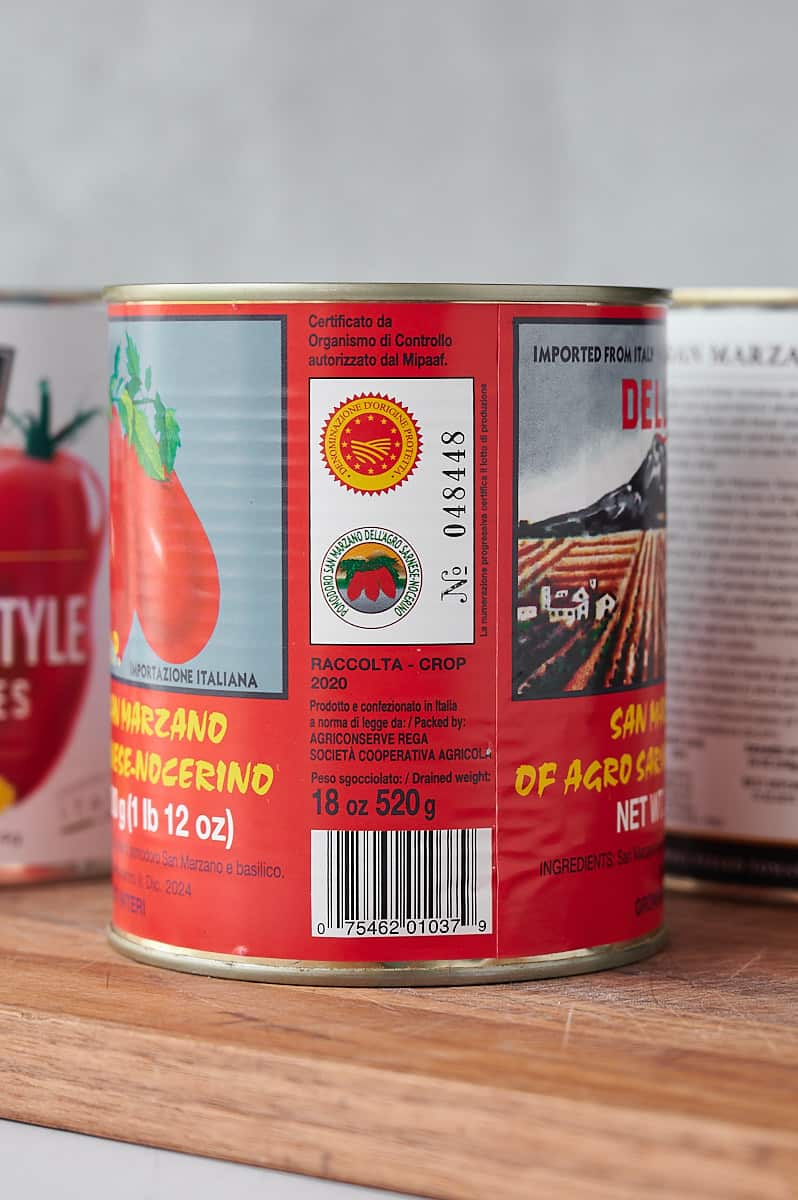 three cans of canned tomatoes with certification on label.