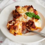 piece of cheese lasagna on a white plate cropped