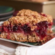 cranberry bars on a plaid plate with white napkin.