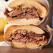 Italian beef sandwiches wrapped in parchment and stacked on top of each other