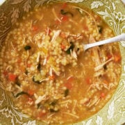 green floral bowl with chicken soup and spoon