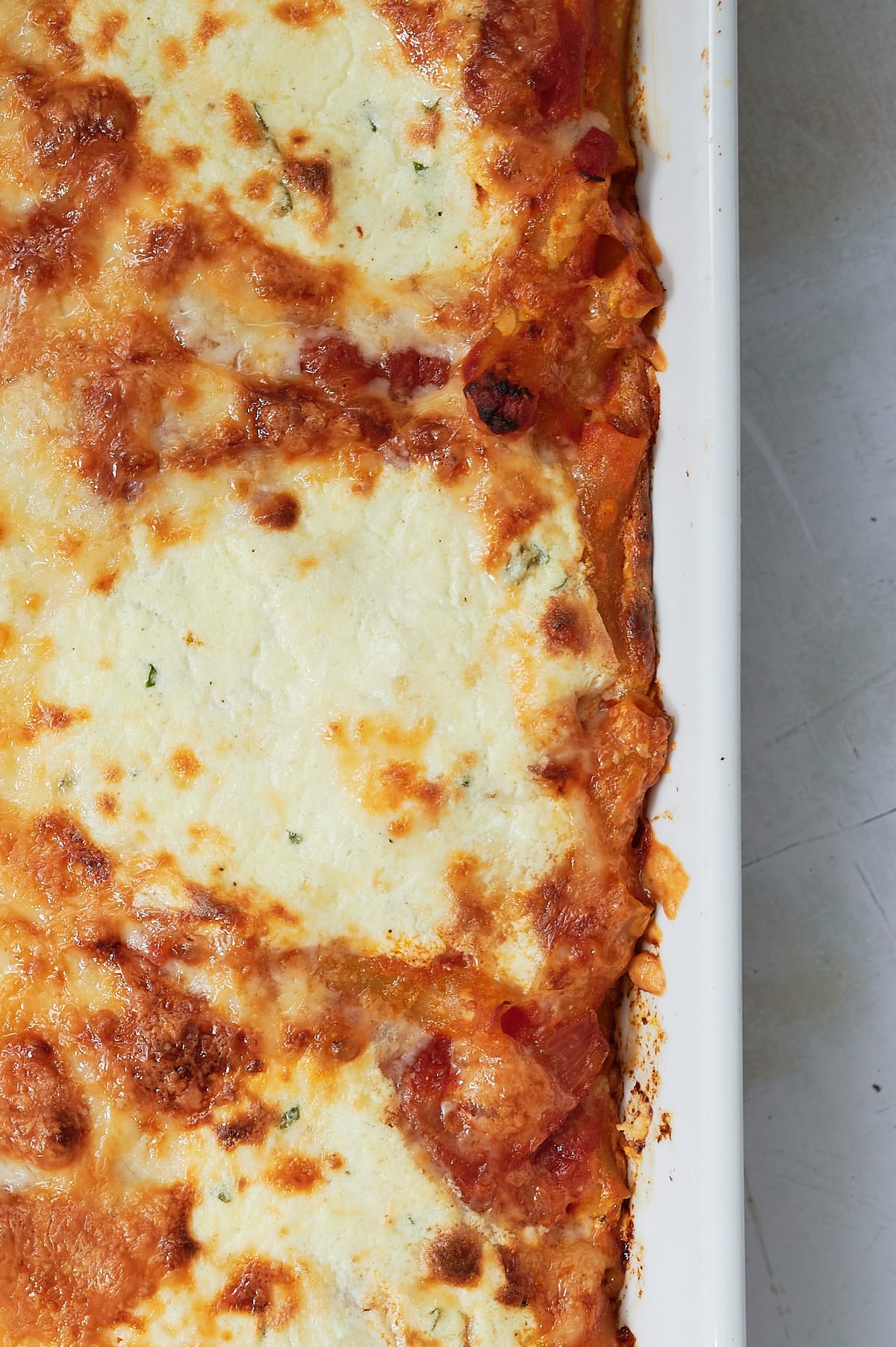 closeup of a pan of baked ziti with cheese on top