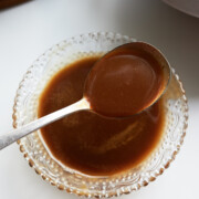 cut glass bowl with honey balsamic dressing and a spoon in it