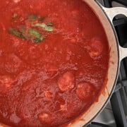 a finished white pot of meatballs cooking in sauce