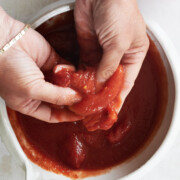 hand crushing of canned whole tomatoes for Neapolitan pizza sauce