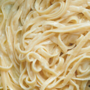 close up of creamy alfredo sauce on fettuccine