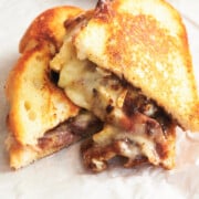 angled shot of golden brown brie grilled cheese sandwiches on parchment