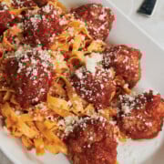 white platter with meatballs and tagliatelle with parmesan cheese