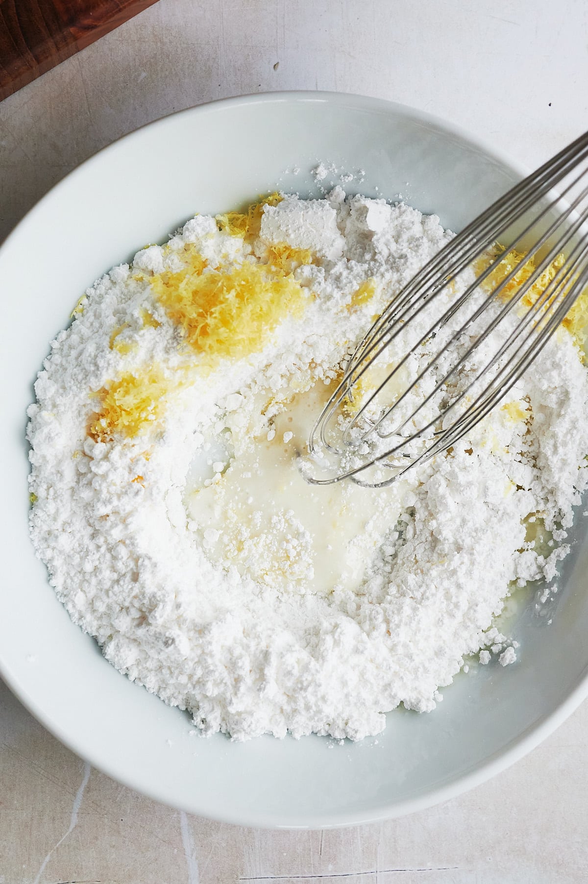 white bowl with lemon knot glaze being whisked.