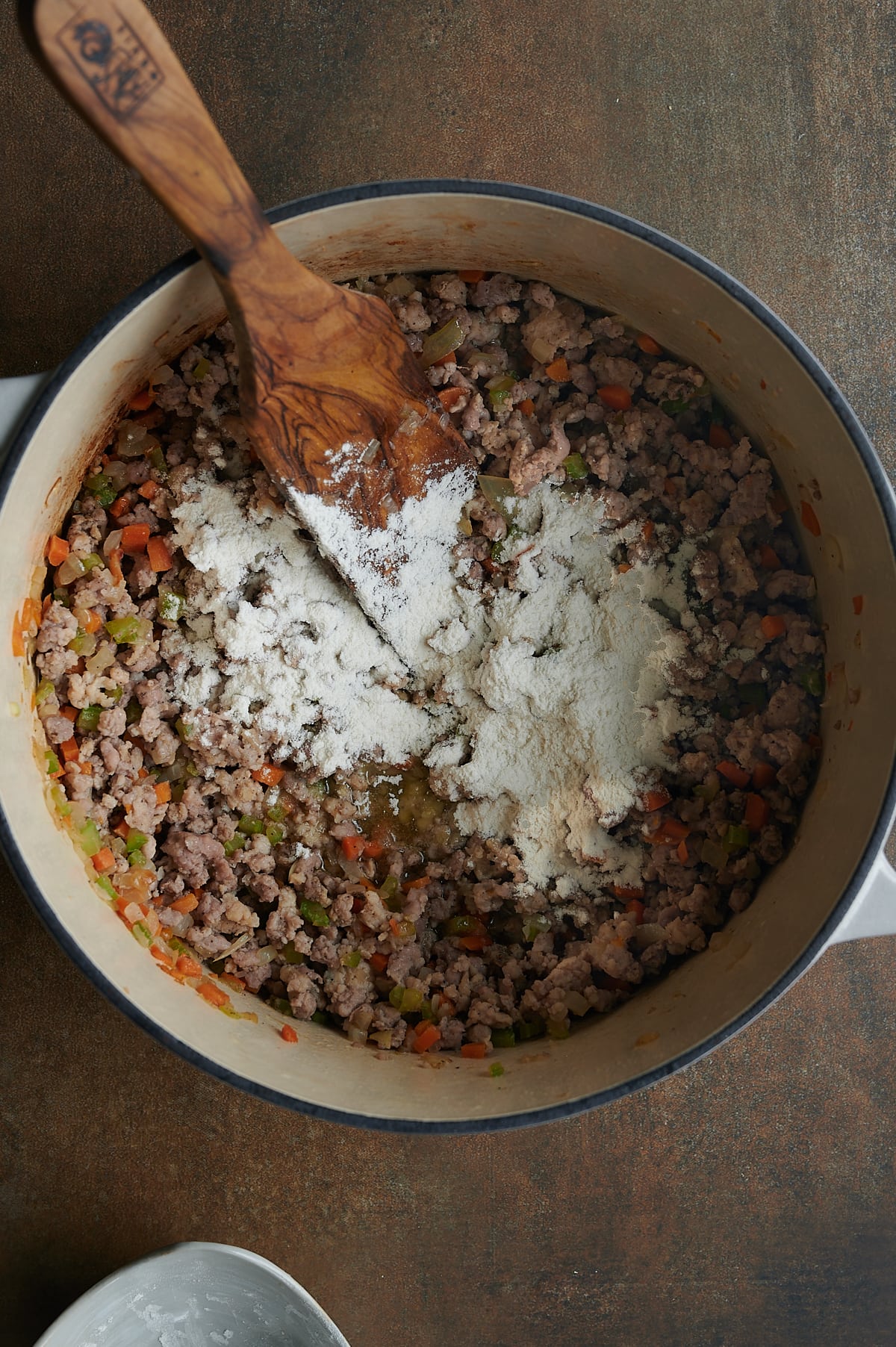 white Dutch oven with flour added to thicken ground meats.