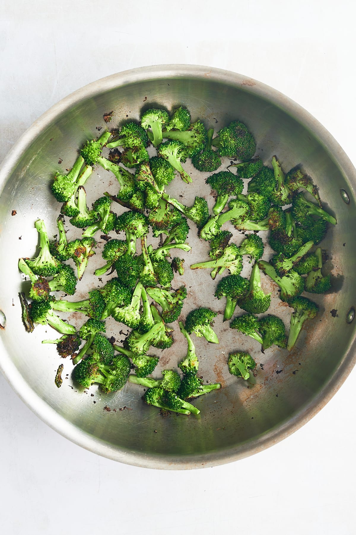 stainless skillet of charred broccoli.