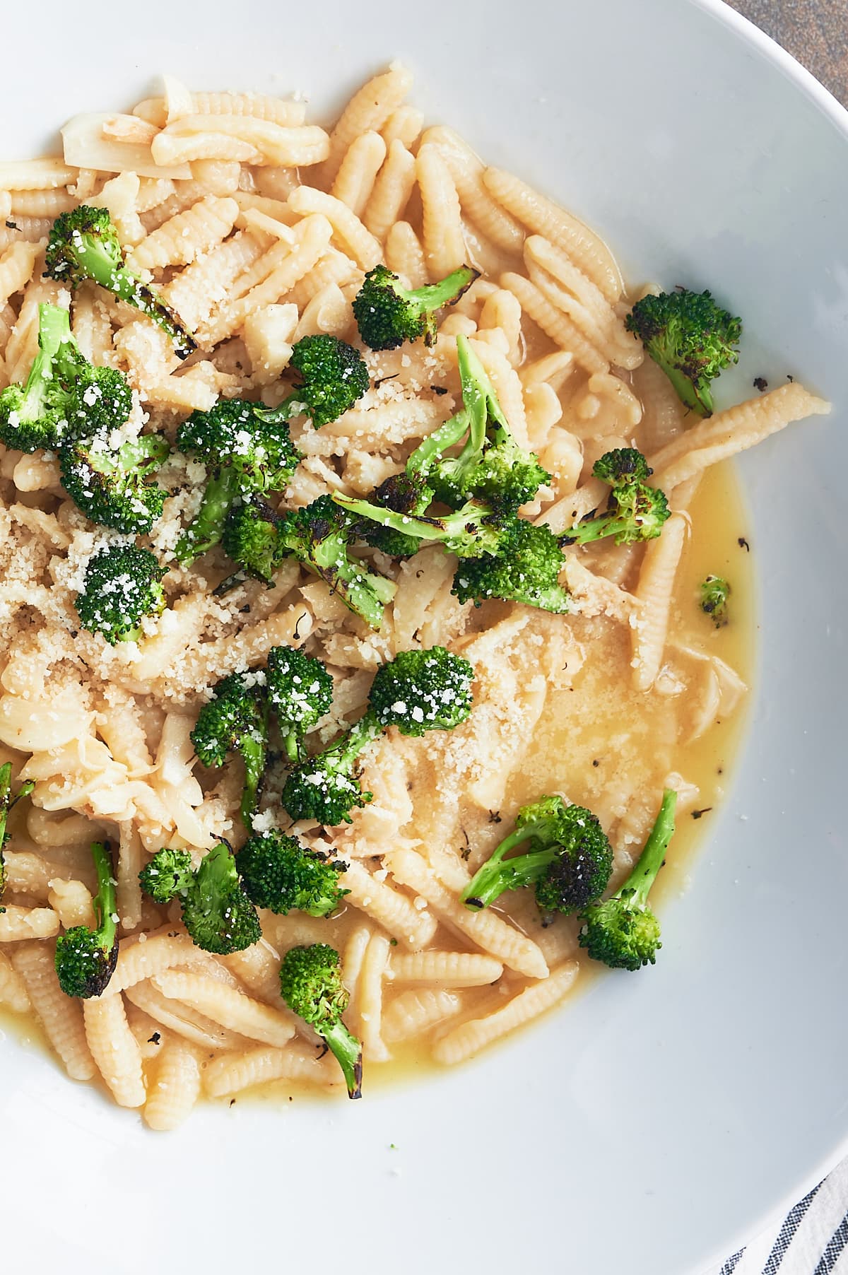 close up of cavatelli and broccoli in a broth.
