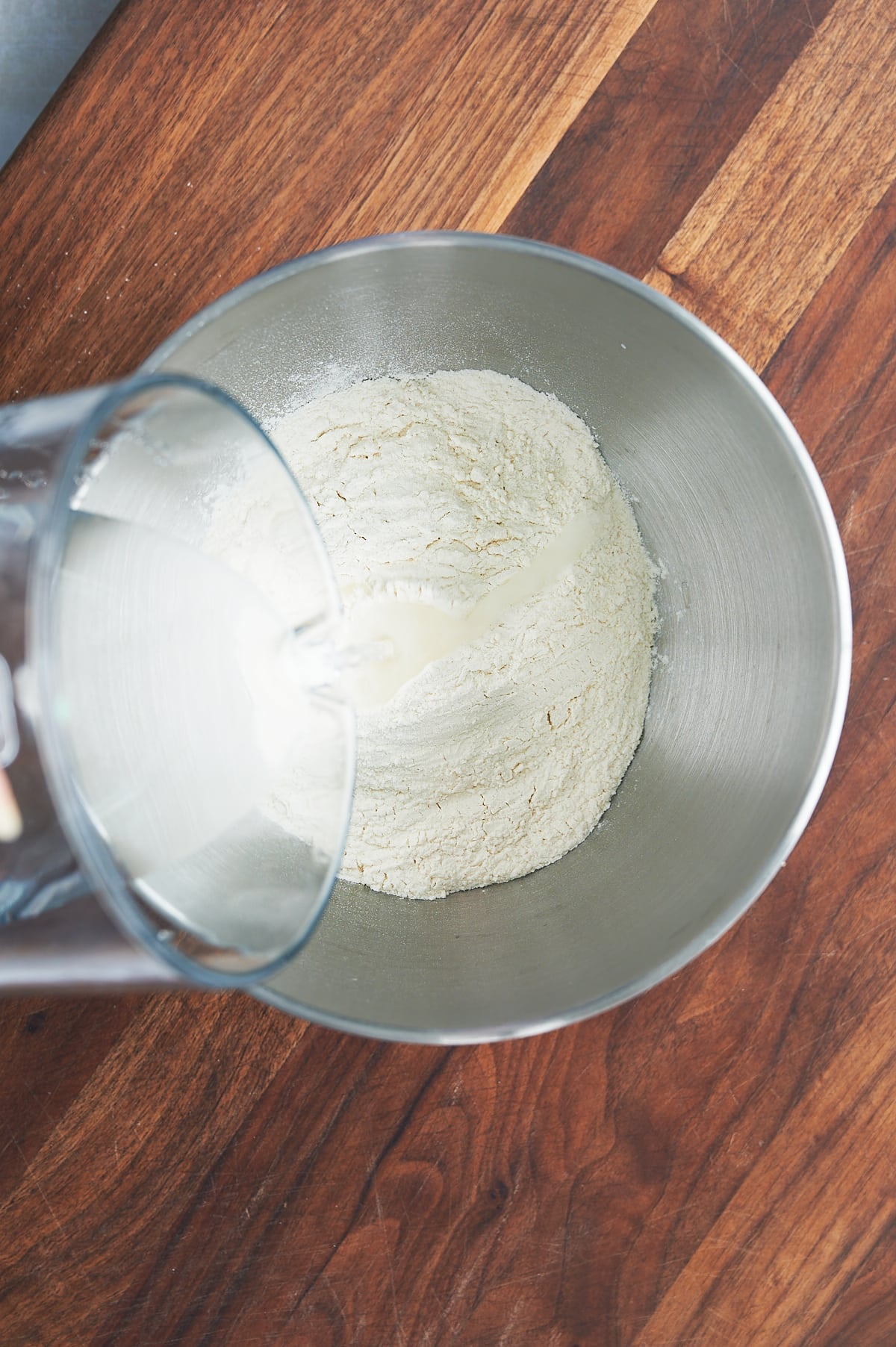 Water being poured into flour for autolyse.