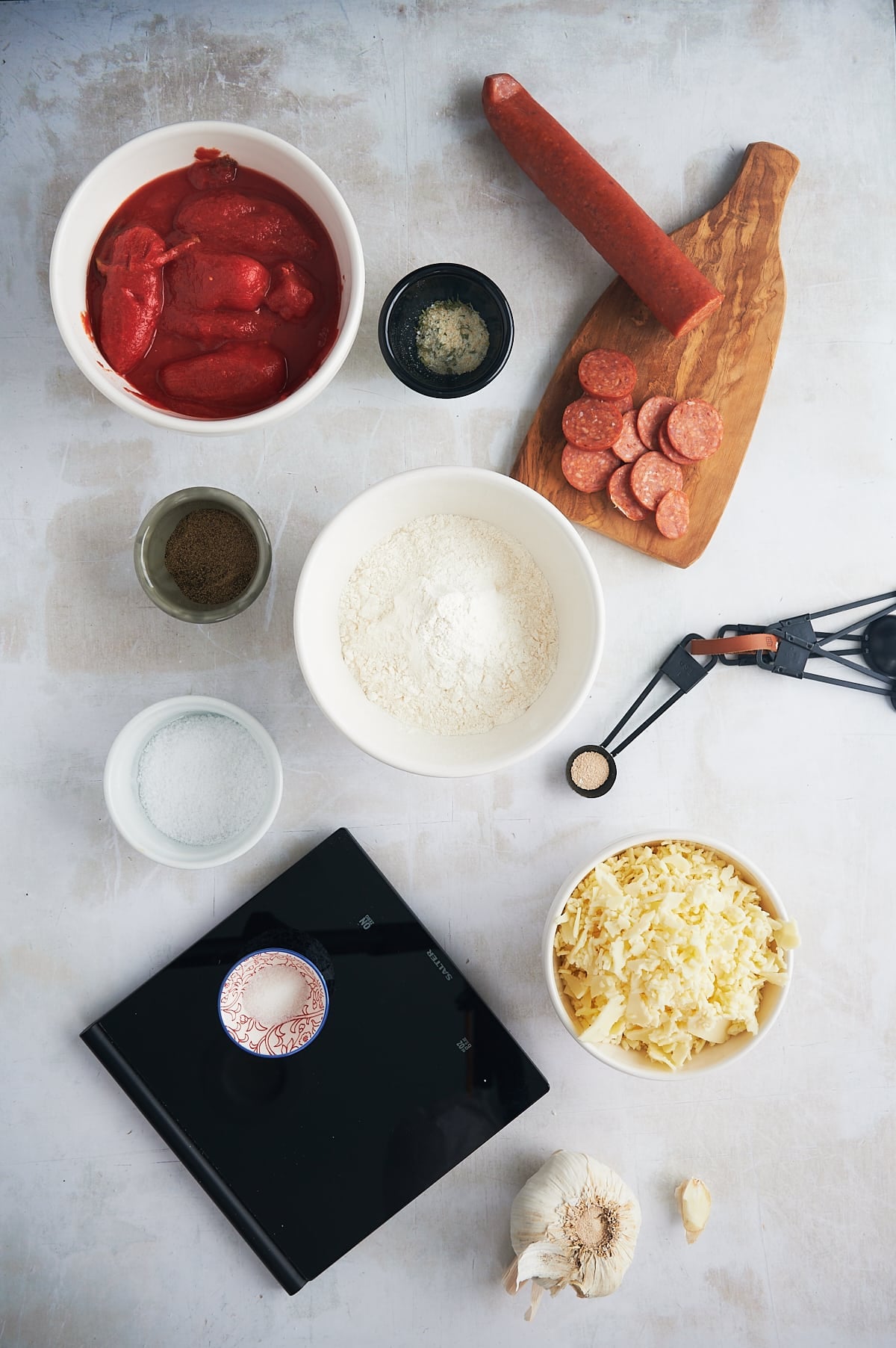Ingredients for pepperoni pan pizza on white background.