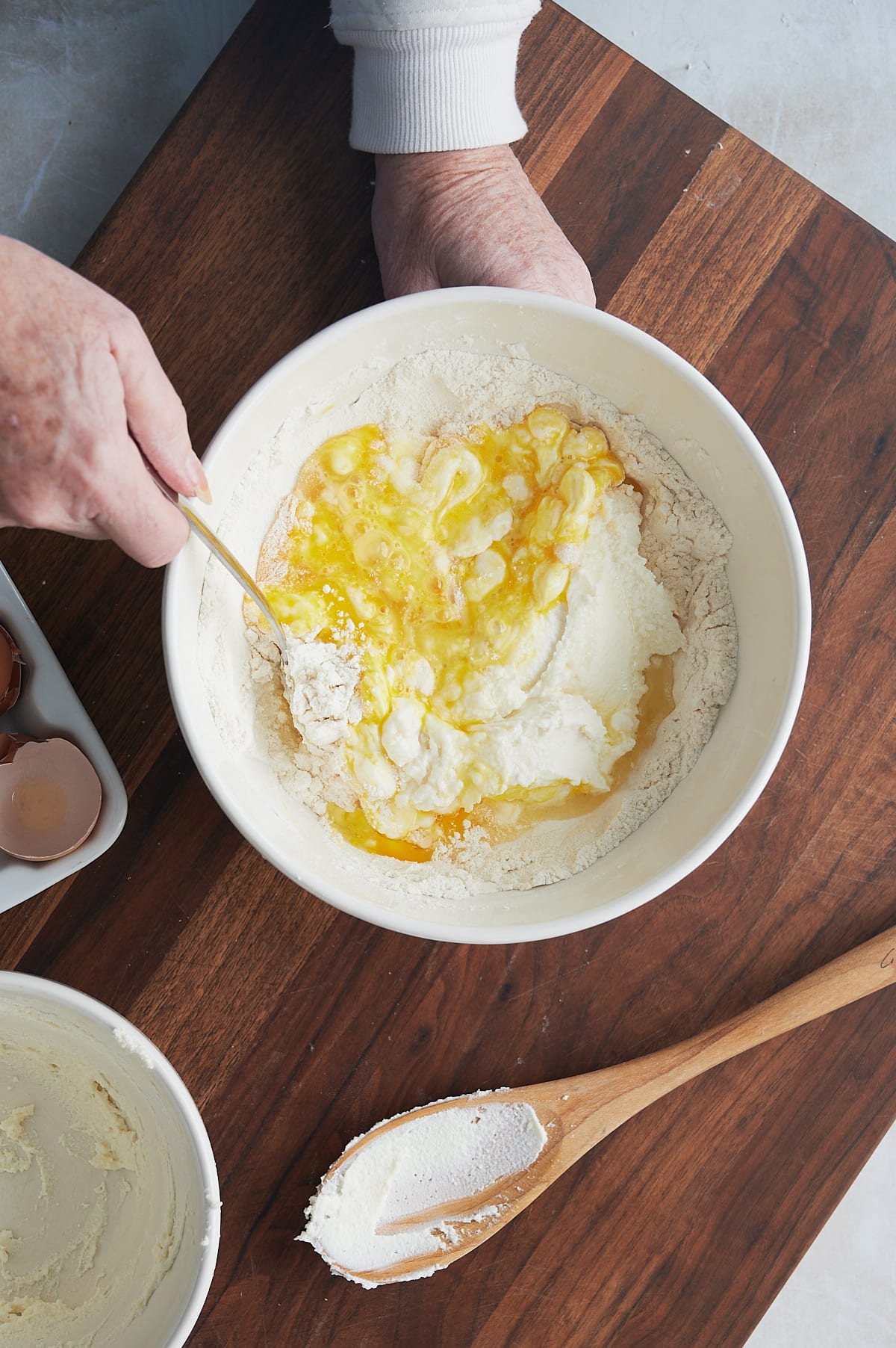 hands mixing bowl of eggs, flour and ricotta cheese for cavatelli