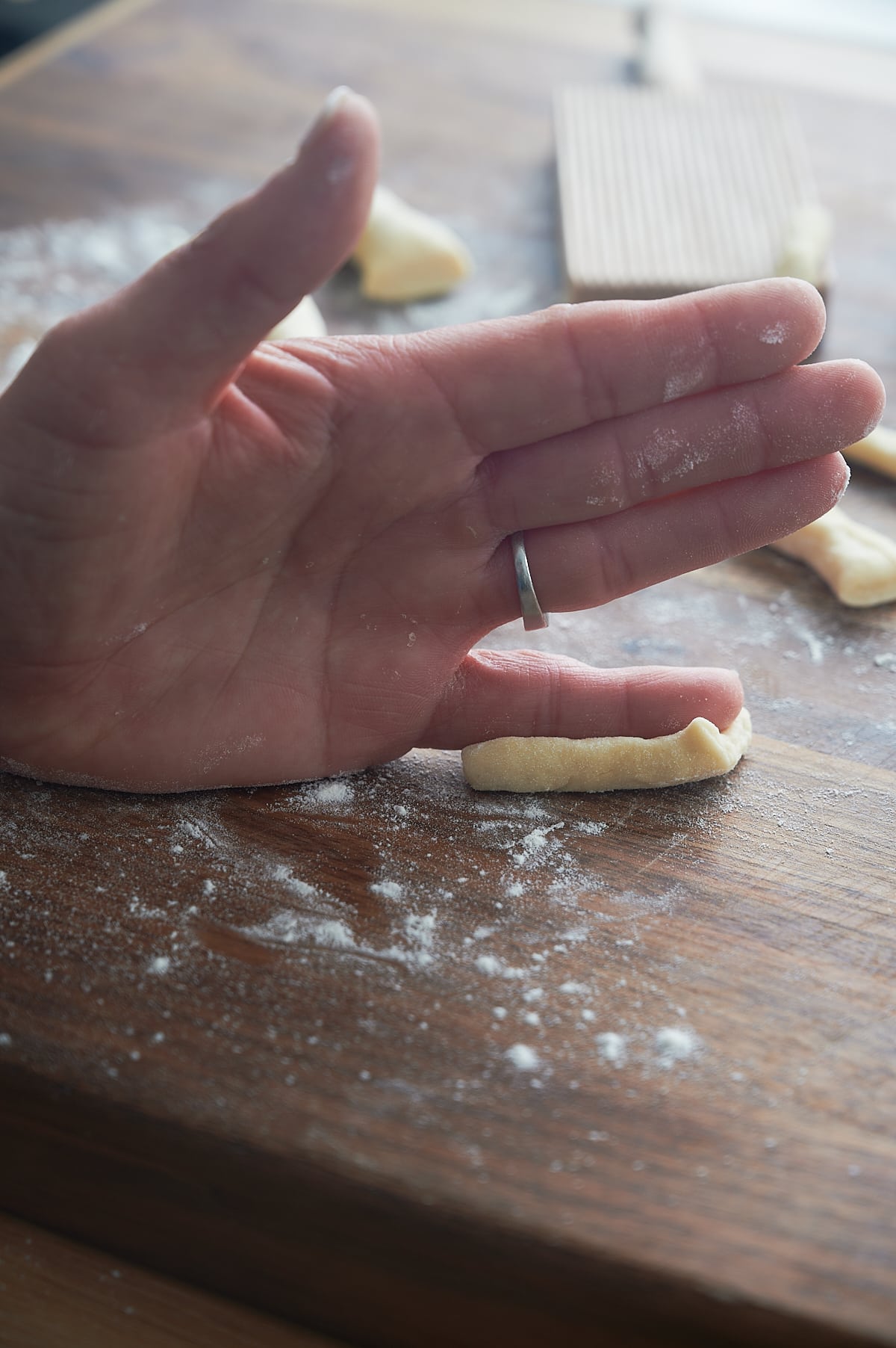 hand using pinky finger to shape homemade cavatelli pasta.
