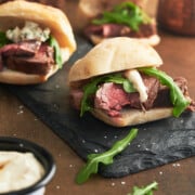 Beef tenderloin slider sandwiches with horseradish sauce on it