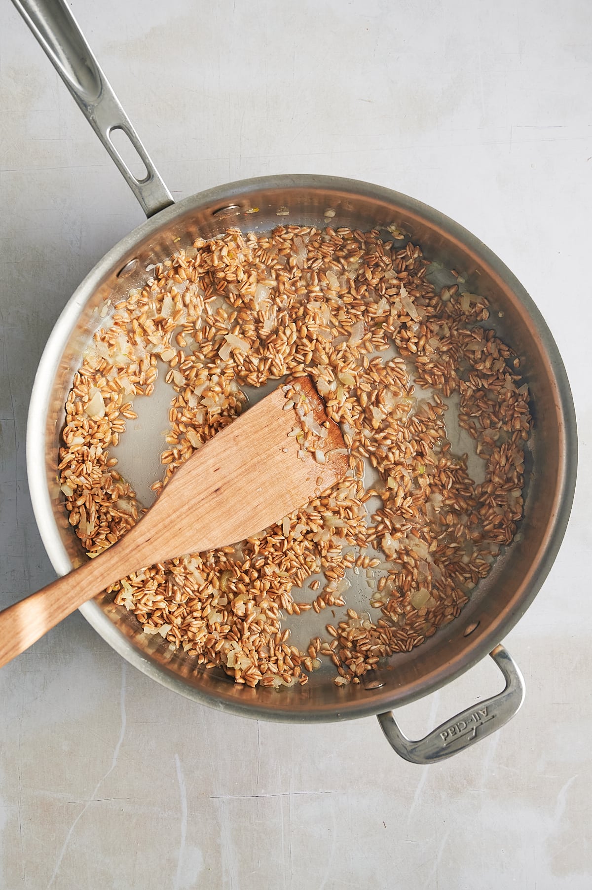 wine being absorbed by pan of parmesan farrotto