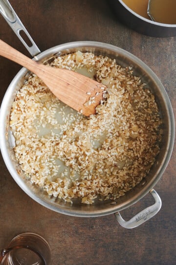 Adding first ladle of stock to toasted risotto