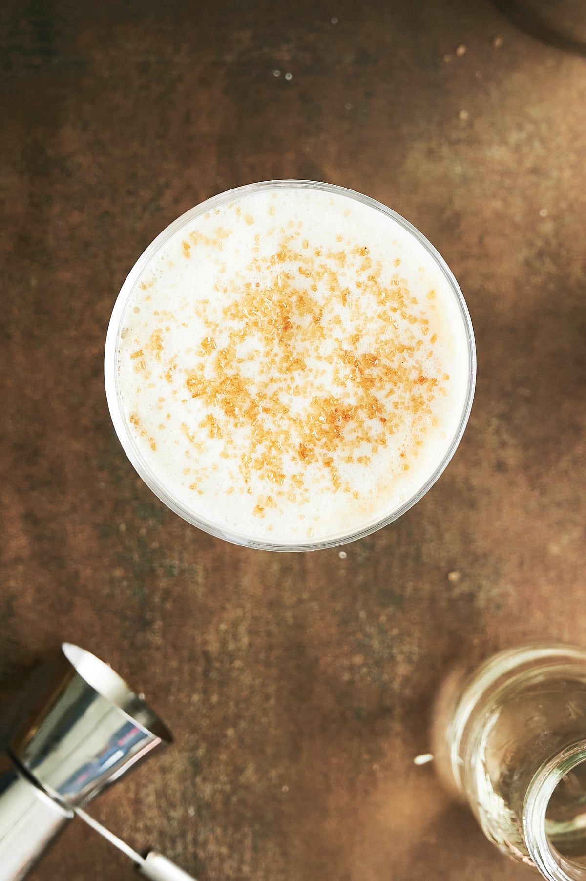 Frothed milk topped amaretto coffee sprinkled with sugar.