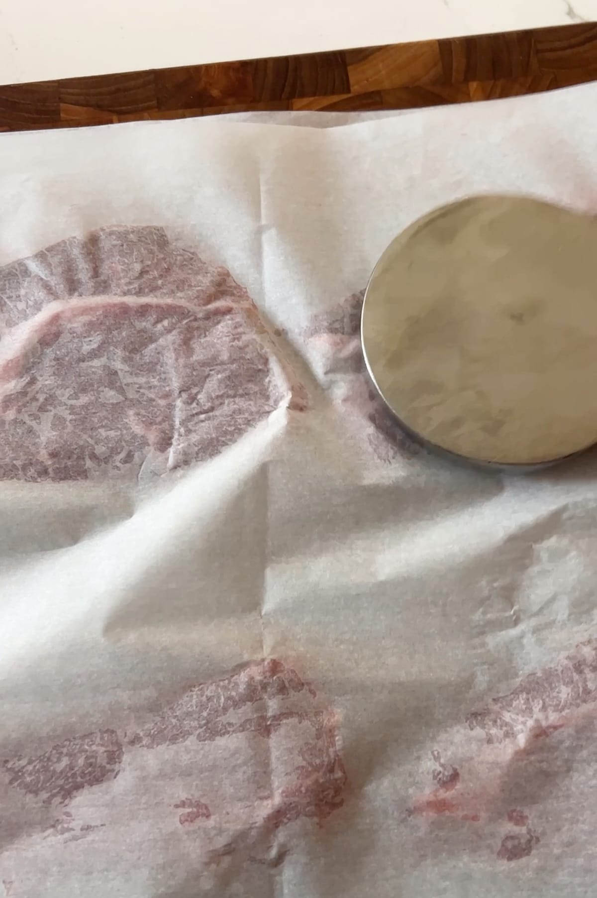 Pounding beef between sheets of parchment for braciole.