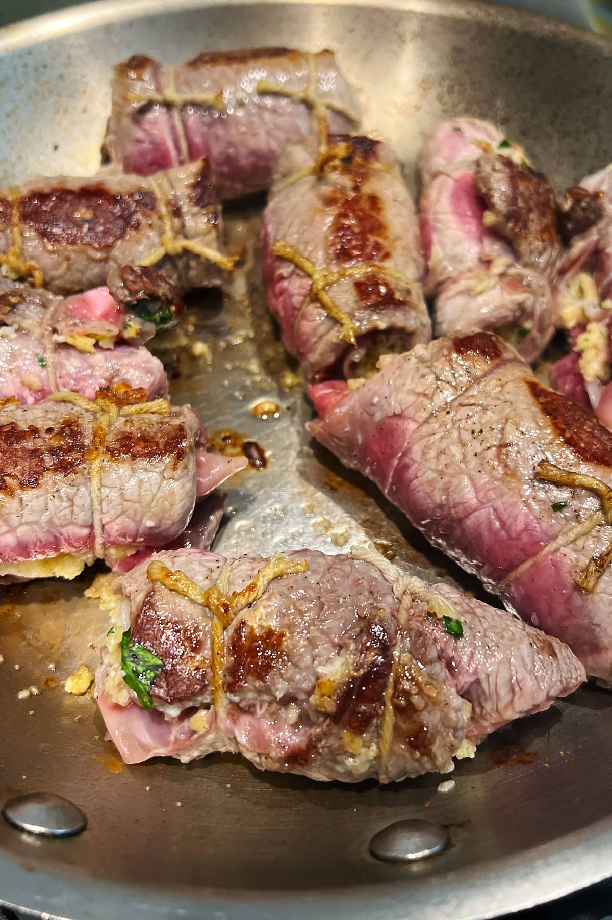 pan of browned braciole being seared.