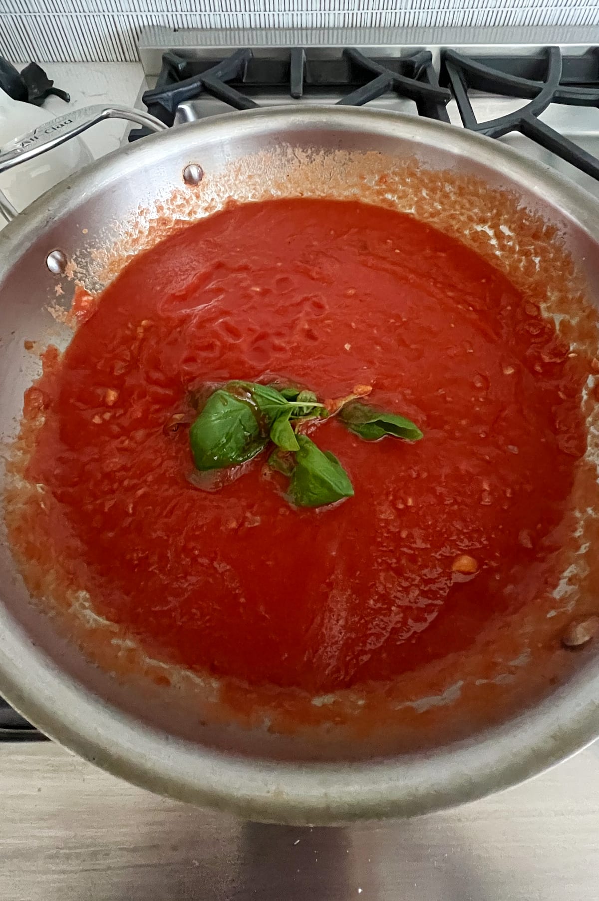 pan of tomato sauce with basil.