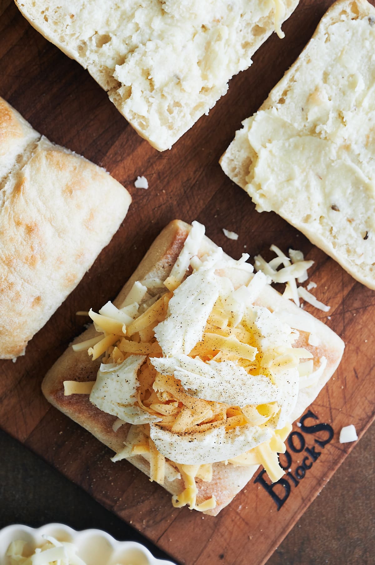 Open faced ciabatta rolls topped with grated cheese and torn fresh mozzarella.