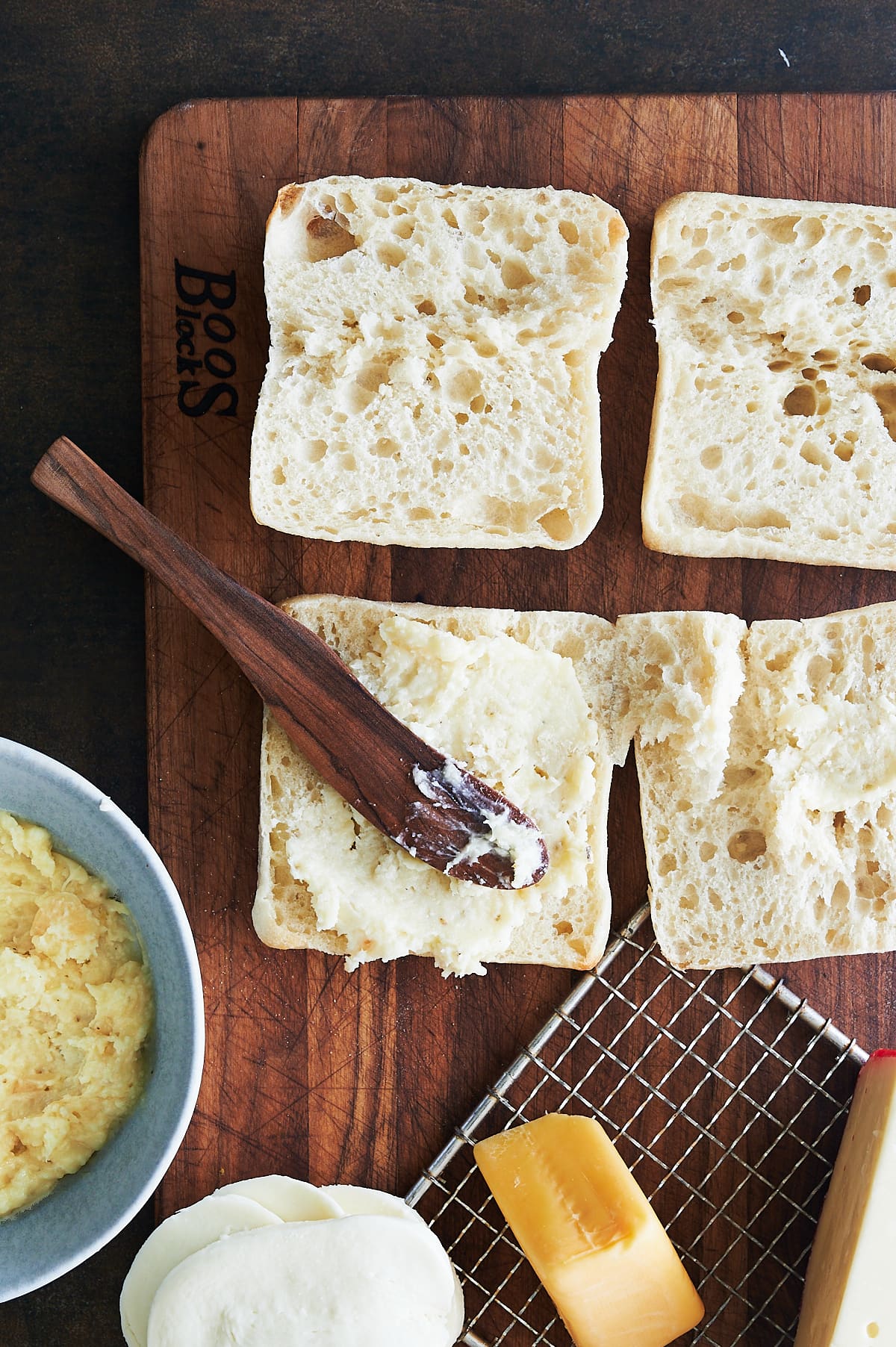 Spreading butter on ciabatta for grilled cheese.