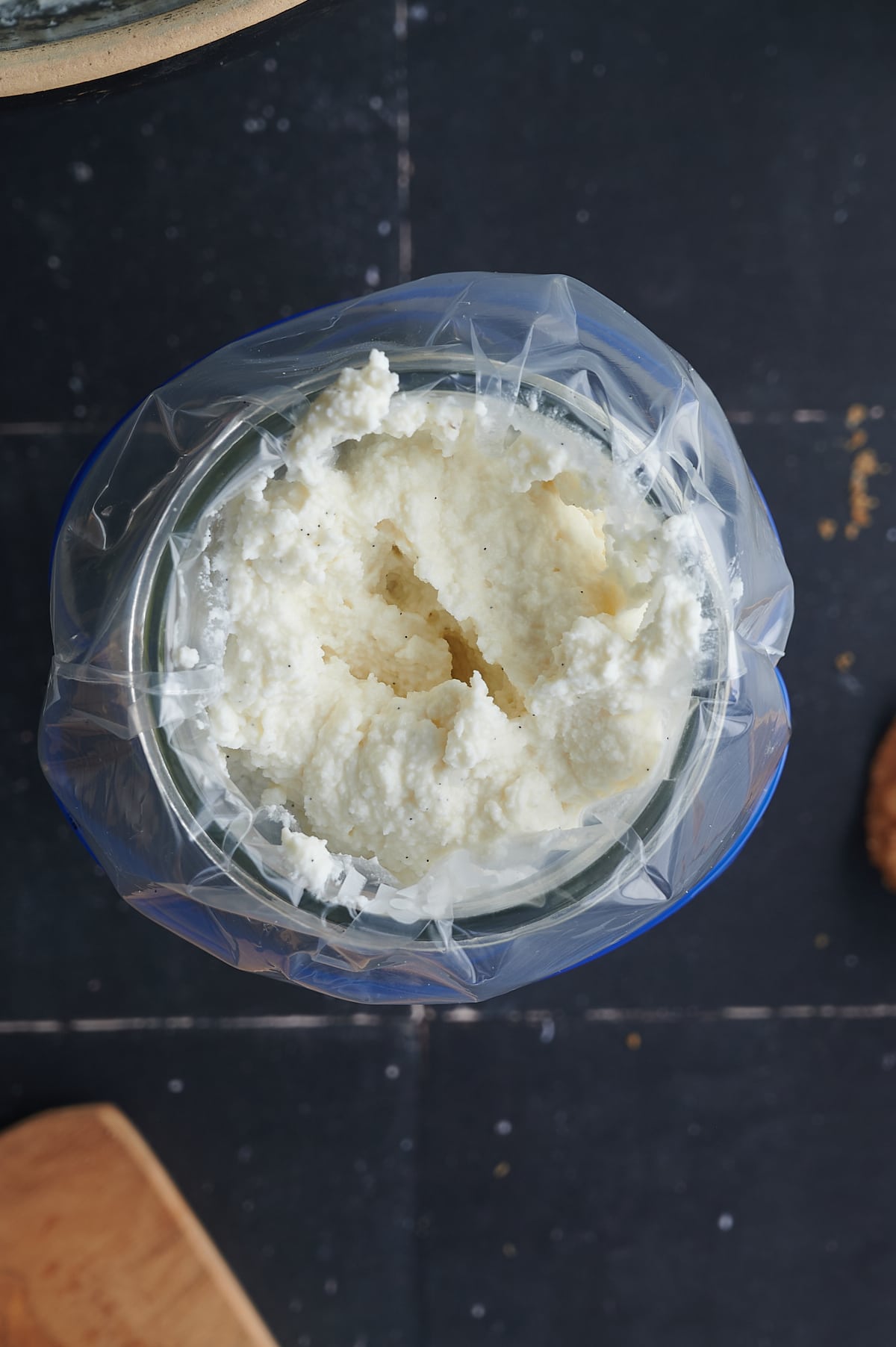 glass with bag of cannoli filling resting in it.