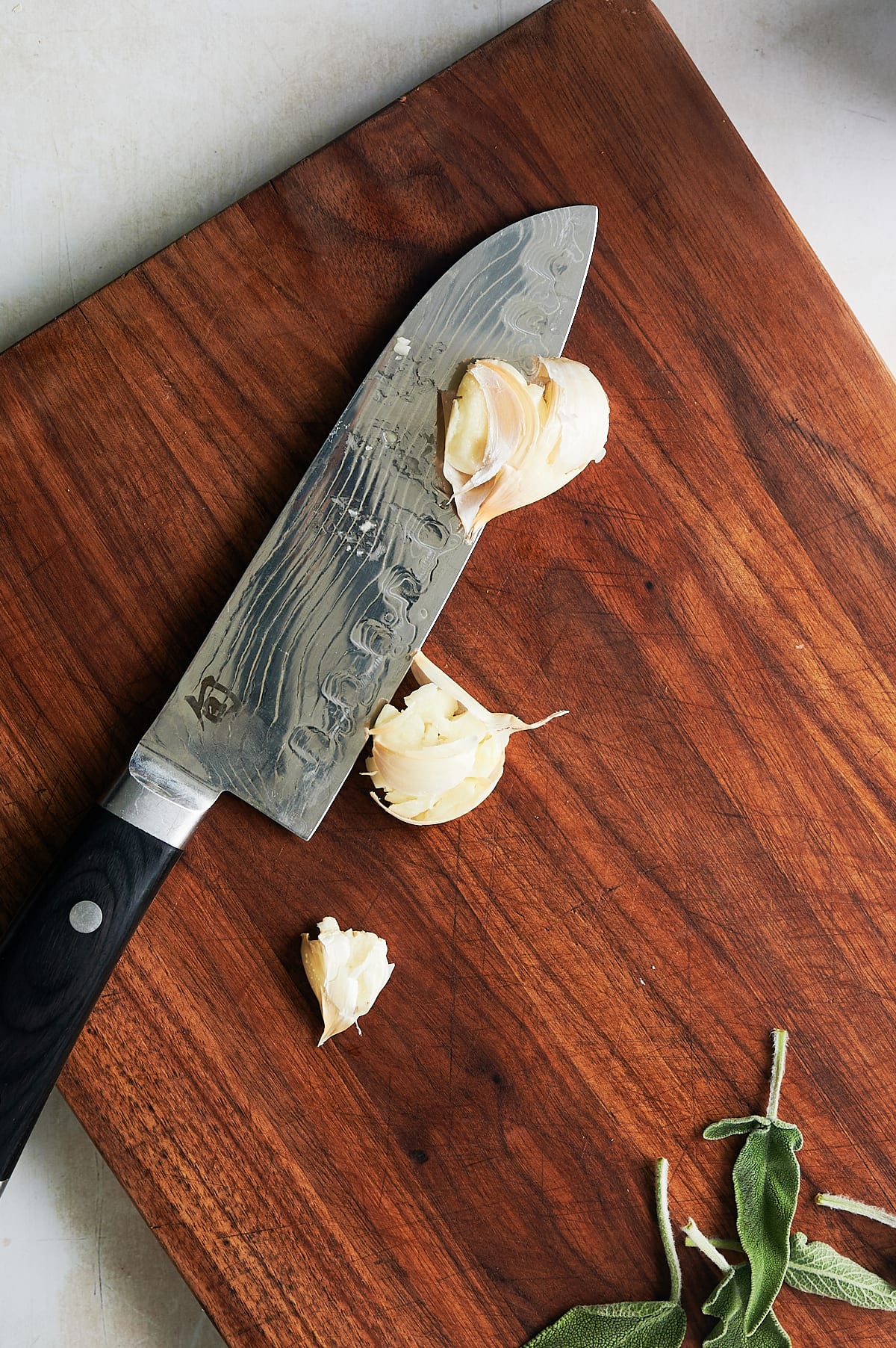 knife smashing garlic cloves to peel them.