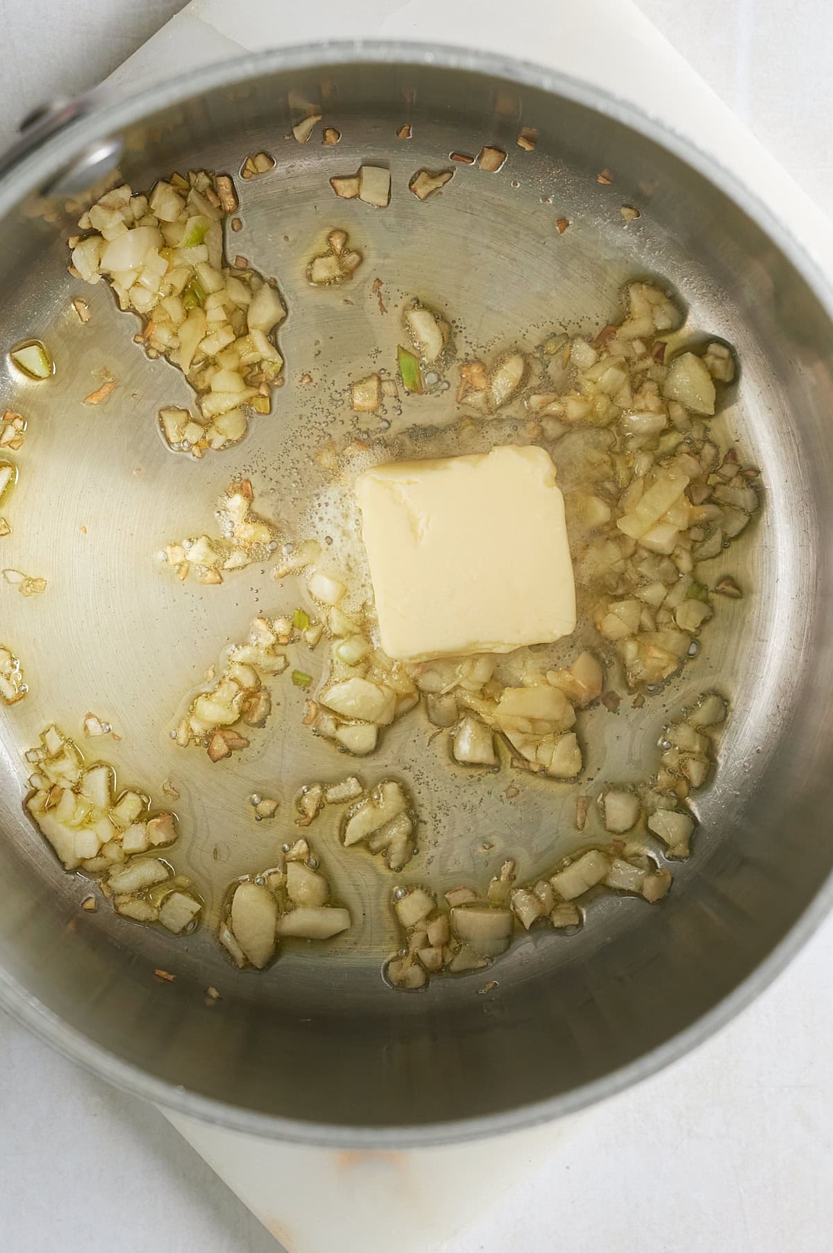 saucepan of onions and garlic sauteing in olive oil with pat of butter.