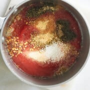 saucepan of marinara dipping sauce with seasoning on top.