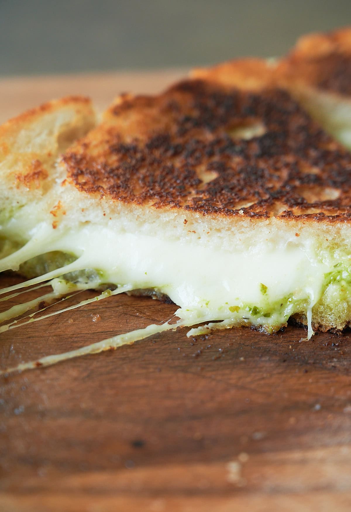 close up of pesto grilled cheese with big cheese pull.