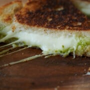 close up of pesto grilled cheese with big cheese pull.