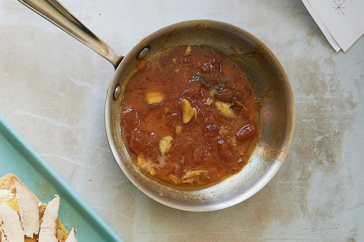 skillet of peach spread with garlic and fresh thyme.