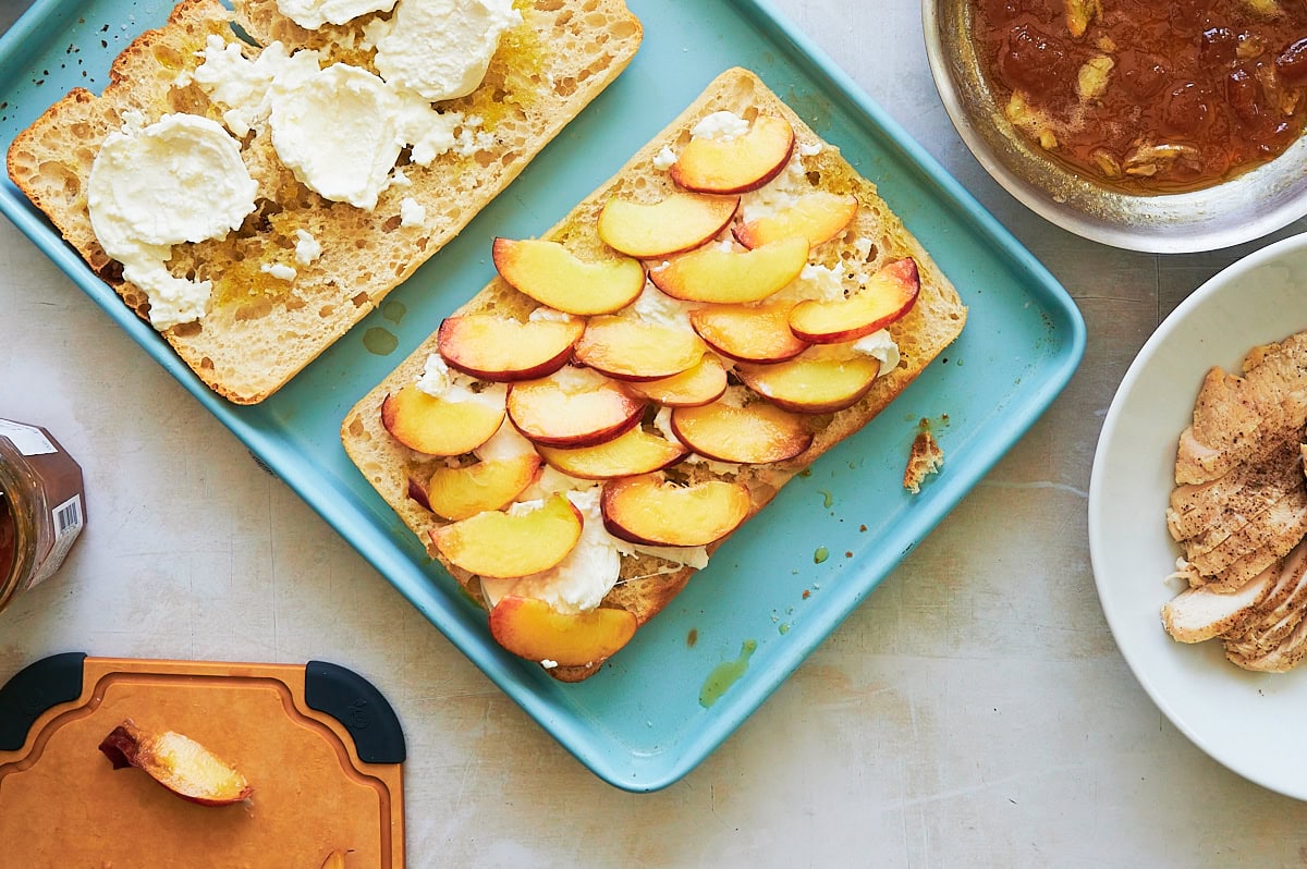 large ciabatta bread layered with burrata topped with sliced peaches.