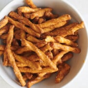 white bowl of honey mustard butter braid pretzels on a white background.