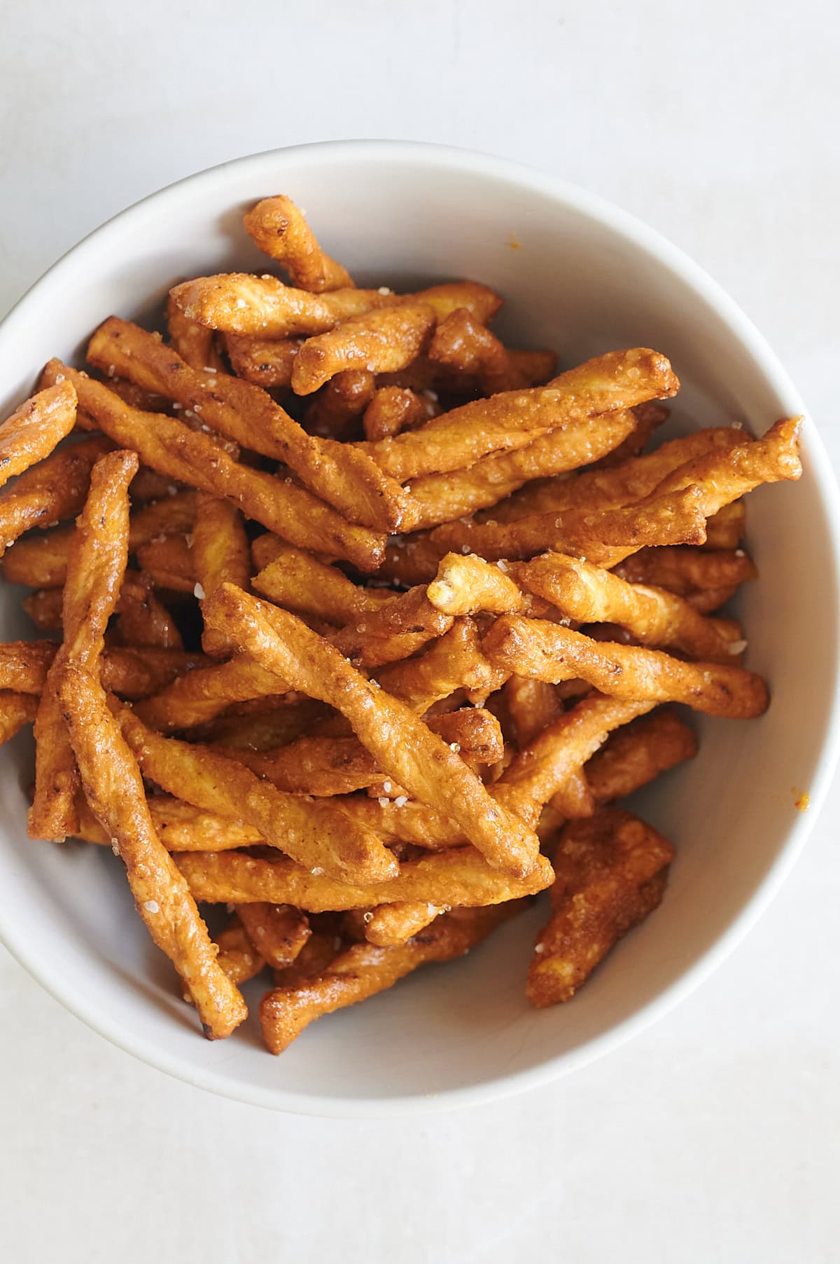 white bowl of honey mustard butter braid pretzels on a white background.