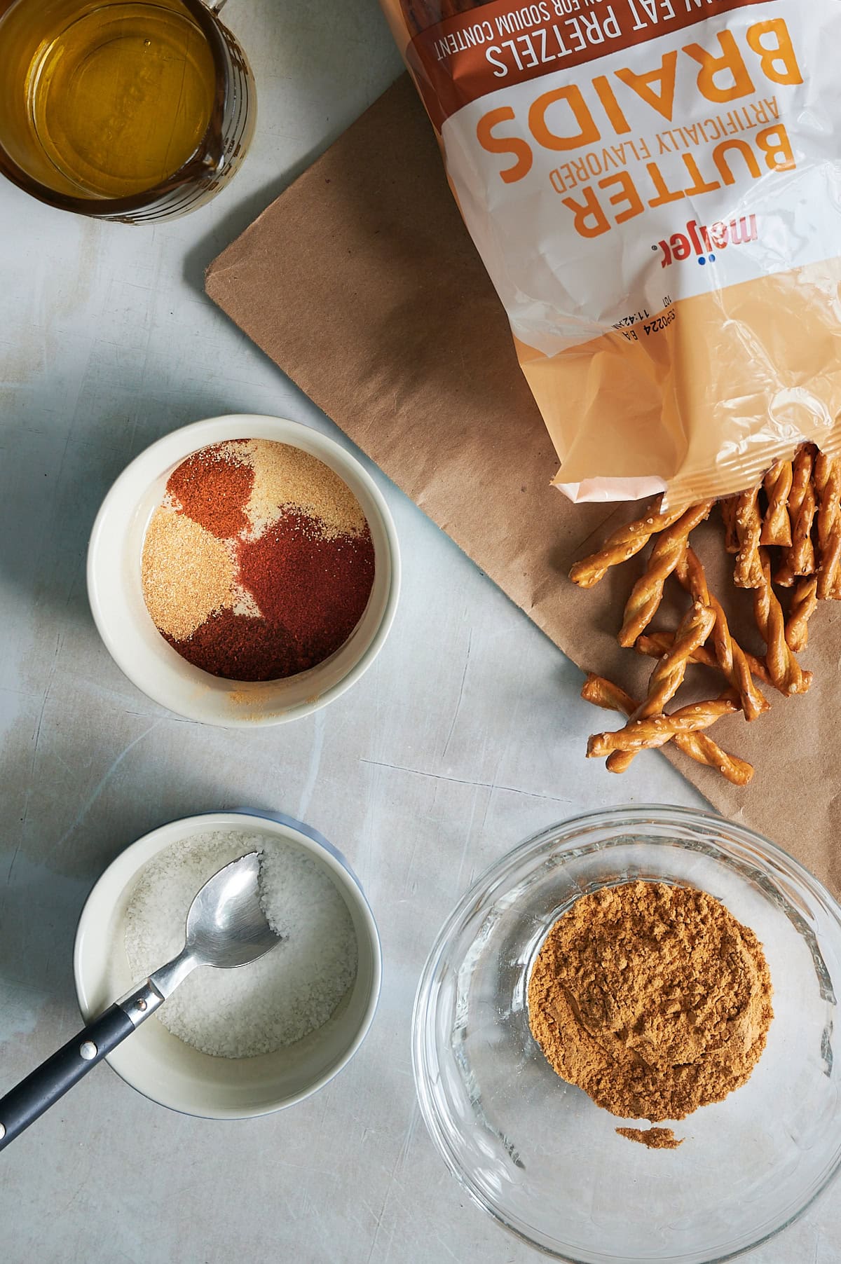 Ingredients for southwest seasoned pretzels include butter braid pretzels, seasonings in white bowls and salt.