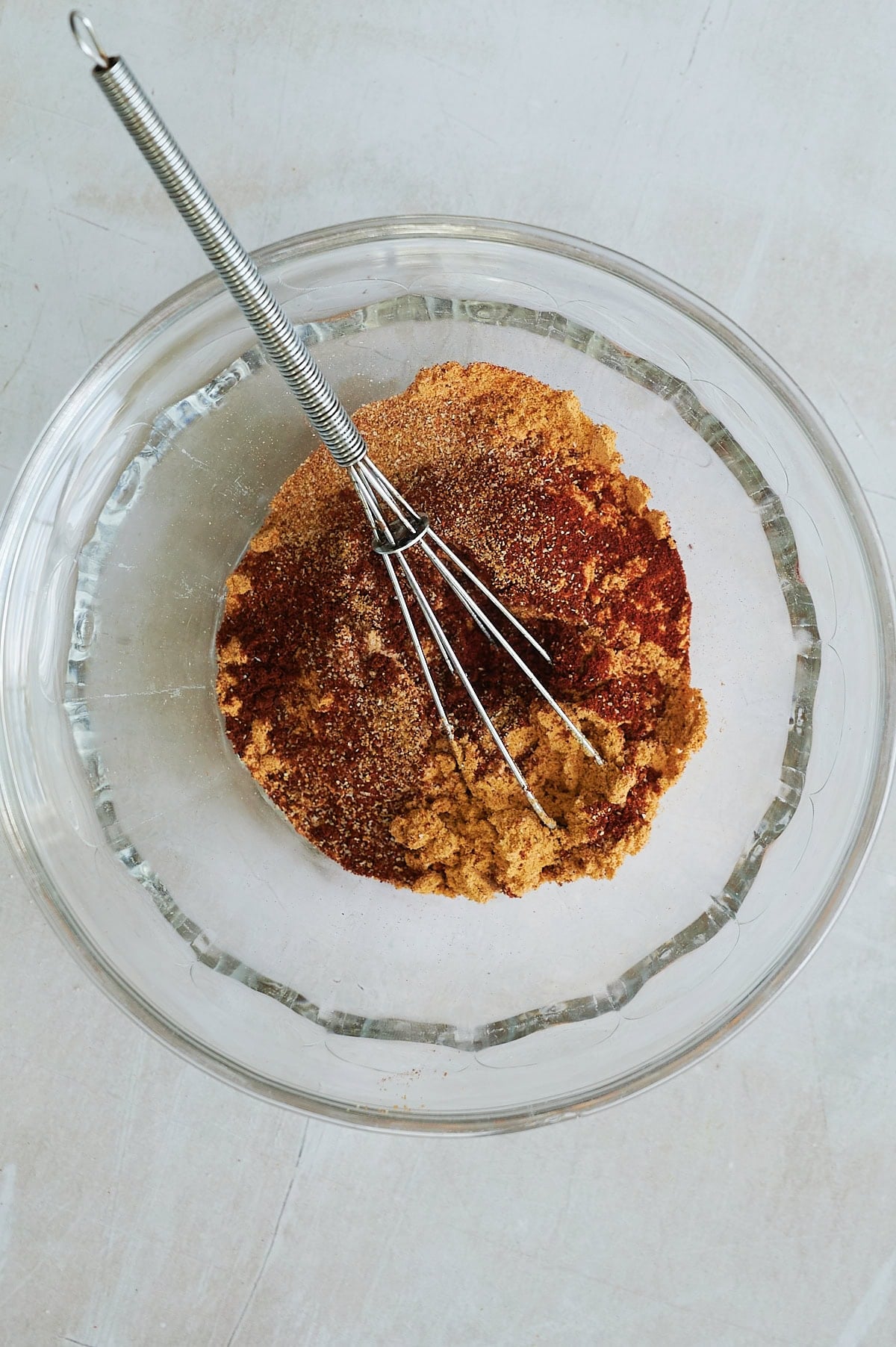 clear bowl with spice blend being whisked