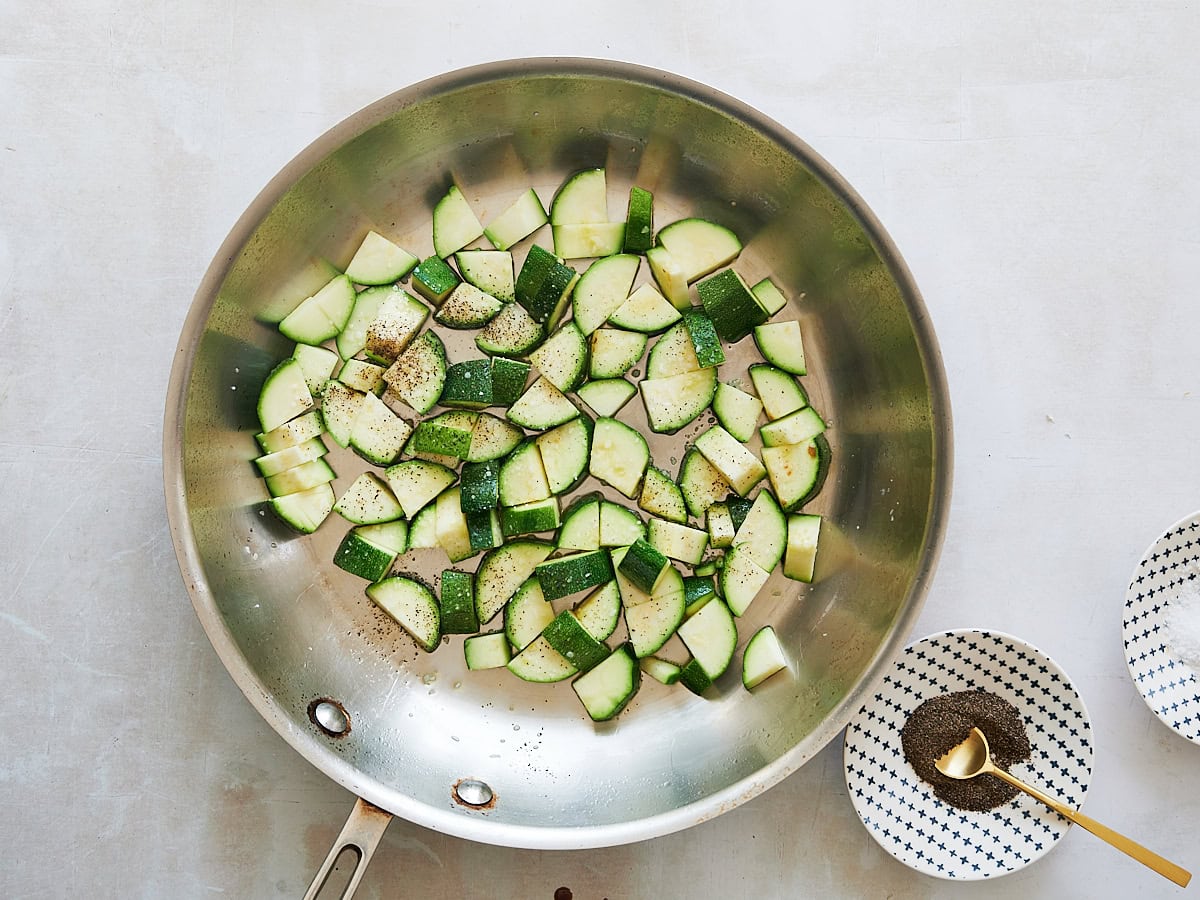 Zucchini tossed with oil in a stainless skillet and seasoned with salt and pepper.