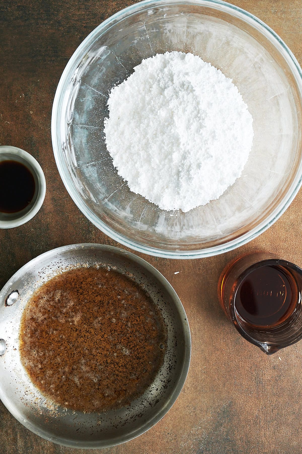 Bowls with powdered sugar, syrup, vanilla and brown butter for glaze.